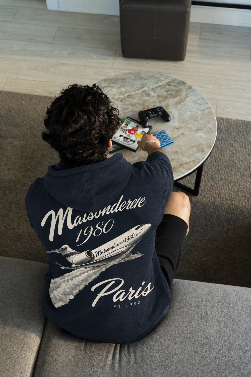 Maison de Rêve Paris navy hoodie, worn in a lounge